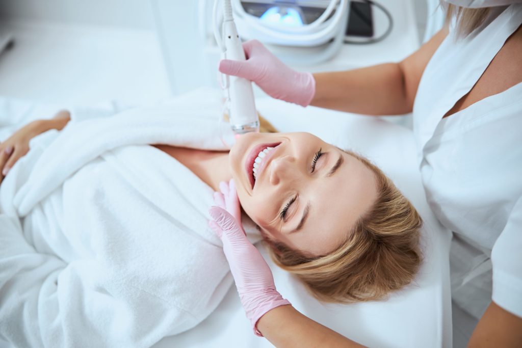 Smiling Woman Receiving Morpheus8 Microneedling Treatment | Purely Natural Medical Spa in Brooklyn, NY